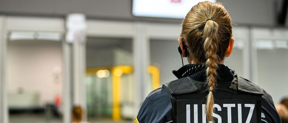 Eine Justizbeamtin steht vor dem Verhandlungssaal im temporären Gerichtsgebäude des Landgerichtes Magdeburg, wo der Prozess gegen den Attentäter vom Magdeburger Weihnachtsmarkt verhandelt wird.