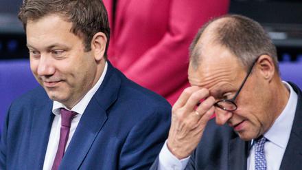 Lars Klingbeil (SPD, l), Bundesminister der Finanzen, und Bundeskanzler Friedrich Merz (CDU) sitzen zu Beginn der Plenarsitzung in der Regierungsbank im Deutschen Bundestag.