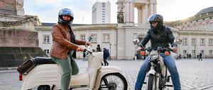 Die Brandenburger Landtagsabgeordneten Nadine Graßmel (l) und Wolfgang Roick (beide SPD) fahren mit ihren Simson-Mopeds auf dem Alten Markt vor dem Landtag vor.