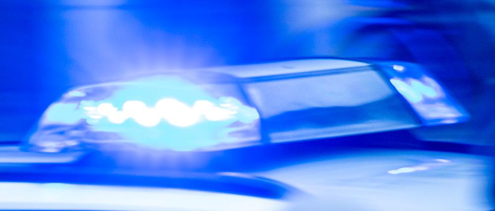 Ein Streifenwagen der Polizei ist mit Blaulicht im Einsatz.
