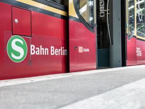 Eine Berliner S-Bahn steht mit geöffneten Türen an einem Bahnsteig. (Archivbild)