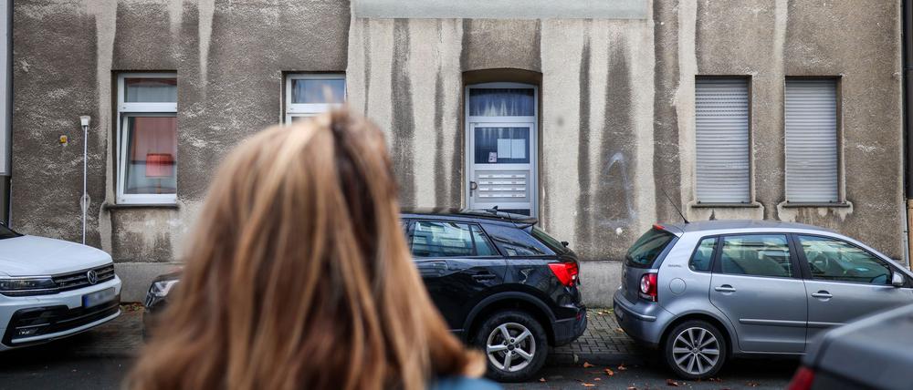 Eine Frau steht vor einem Mehrfamilienhaus. In diesem Mehrfamilienhaus in Bochum ist ein zwölfjähriges Mädchen bei einem Polizeieinsatz durch Schüsse aus einer Dienstwaffe lebensgefährlich verletzt worden.