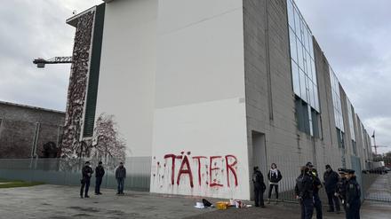 Aktivisten protestieren am 18.11.2025 gegen deutsche Rüstungspolitik, indem sie das Wort ‘Täter’ und rote Handabdrücke an der Wand des Kanzleramts hinterlassen 