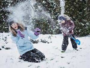 Ein Schneewirbel der anderen Art: ein Junge bewirft seine Mutter mit Schnee.