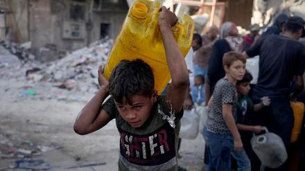 Palästinensische Kinder tragen Kanister mit Wasser, das sie von einem Lastwagen in Gaza-Stadt gesammelt haben (Symbolbild).