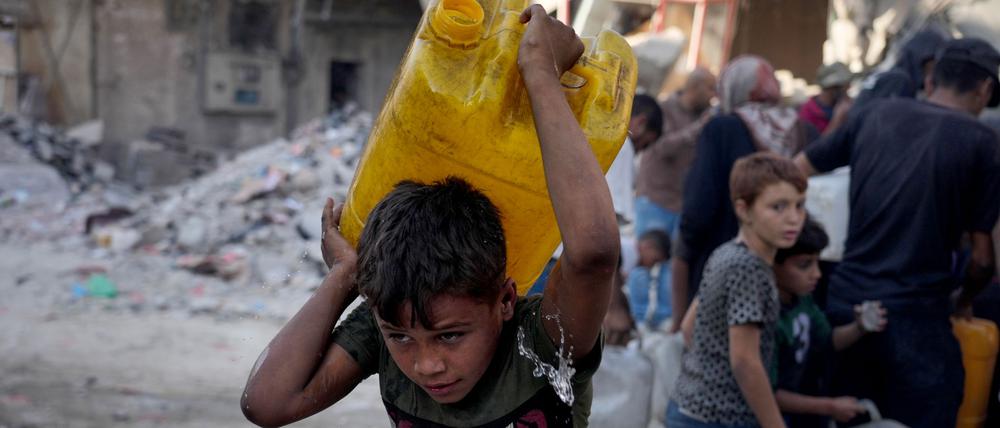 Palästinensische Kinder tragen Kanister mit Wasser, das sie von einem Lastwagen in Gaza-Stadt gesammelt haben (Symbolbild).