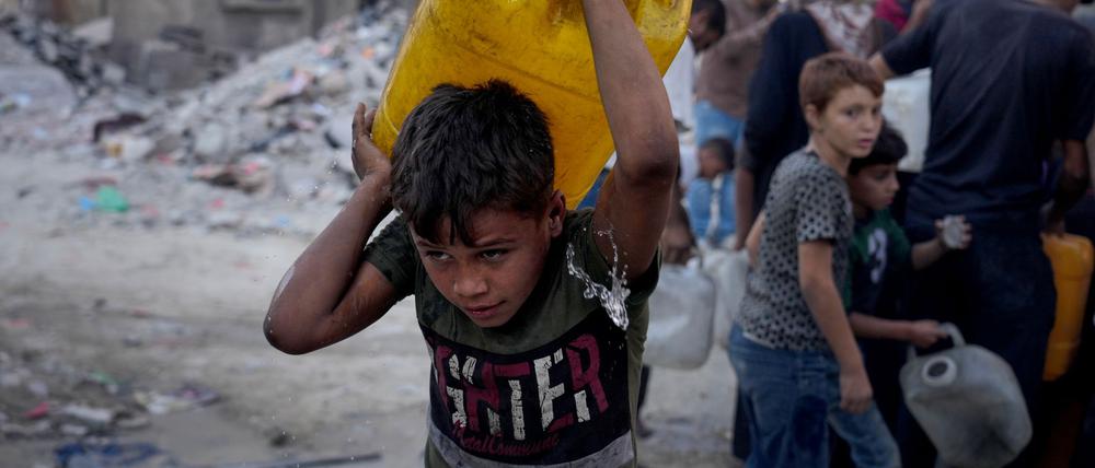 Palästinensische Kinder tragen Kanister mit Wasser, das sie von einem Lastwagen in Gaza-Stadt gesammelt haben (Symbolbild).