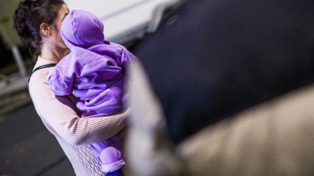 Eine Mutter aus Afghanistan, die zuvor mit ihrem Kind in einem Flugzeug auf dem Flughafen Hannover-Langenhagen gelandet ist, steht vor dem Flughafen. 