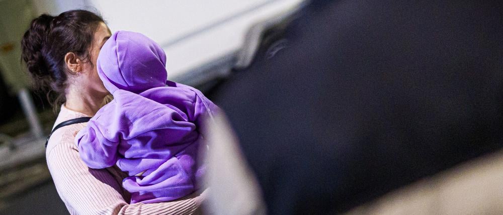 Eine Mutter aus Afghanistan, die zuvor mit ihrem Kind in einem Flugzeug auf dem Flughafen Hannover-Langenhagen gelandet ist, steht vor dem Flughafen.