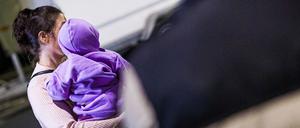 Eine Mutter aus Afghanistan, die zuvor mit ihrem Kind in einem Flugzeug auf dem Flughafen Hannover-Langenhagen gelandet ist, steht vor dem Flughafen.