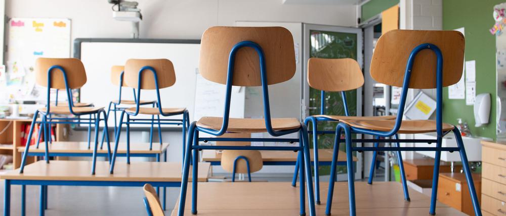 Stühle stehen in einer Schule auf den Tischen.