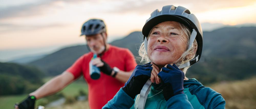 Zwei Menschen sind mit dem Rad unterwegs. Wer sich regelmäßig bewegt, bleibt in der Regel länger fit.