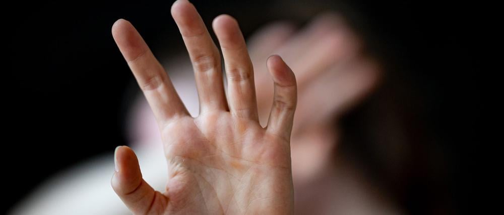 Eine Frau hält ihre Hände vor das Gesicht.