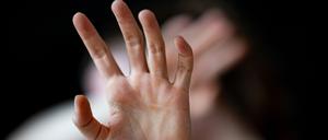 Eine Frau hält ihre Hände vor das Gesicht.