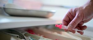 Ein Arzt nimmt in der Berliner Aids-Hilfe für eine Untersuchung eines HIV-Tests eine Spritze für die Blutabnahme aus einer Schublade.