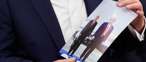 Donald Trump hält ein Foto von sich mit Wladimir Putin in der Hand