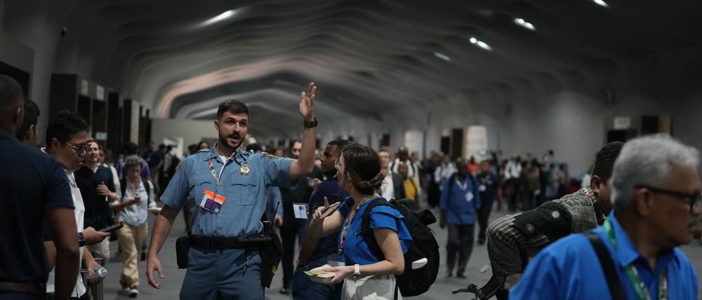 Menschen verlassen das Gelände der Weltklimakonferenz COP 30 wegen eines Feuers.