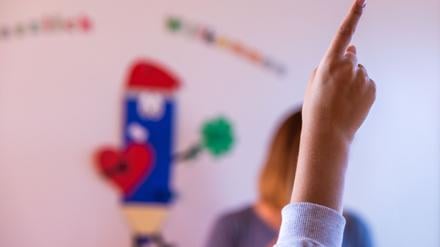 Ein Schüler meldet sich im Klassenraum.