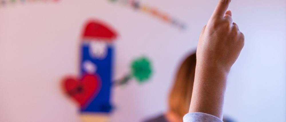 Ein Schüler meldet sich im Klassenraum.