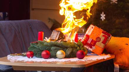 Ein brennender Adventskranz in einem Brandübungscontainer.