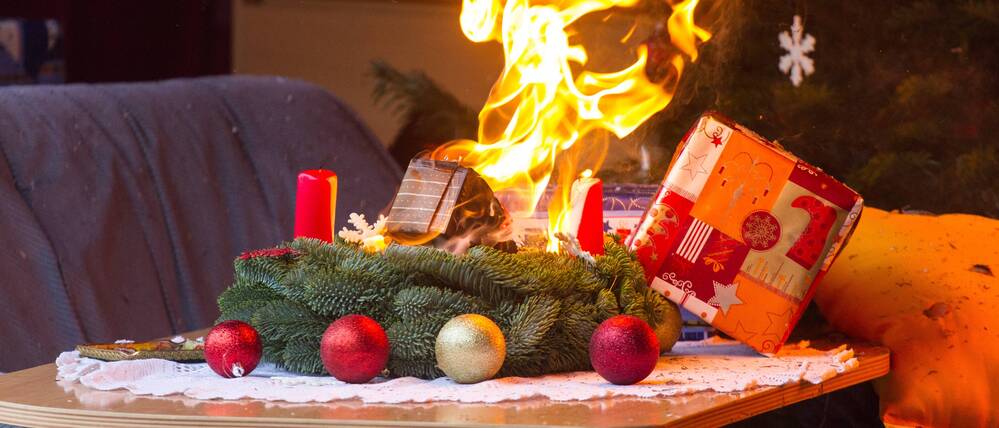 Ein brennender Adventskranz in einem Brandübungscontainer.