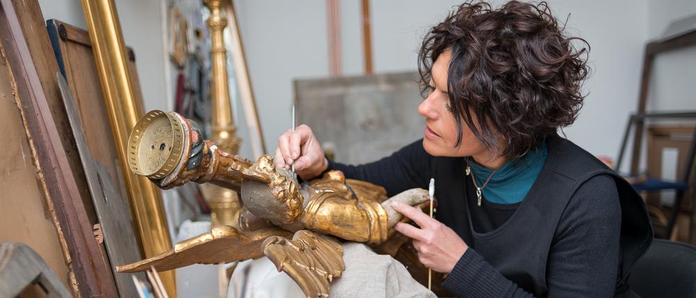 Restaurierung einer antiken goldenen Engelsstatue.