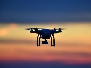 Eine Drohne fliegt bei Sonnenuntergang über eine Wiese. An den deutschen Flughäfen sind im ersten Quartal dieses Jahres mehr illegale Drohnen gesichtet worden als ein Jahr zuvor.