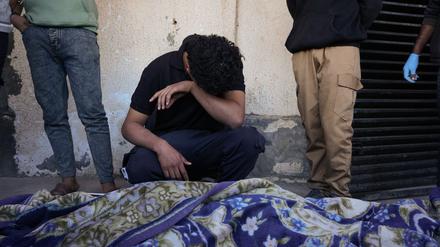 dpatopbilder - 23.11.2025, Palästinensische Gebiete, Deir al-Balah: Ahmed Al-Bohisi trauert um seinen Cousin Mohammad Abu Shawish, 18, der bei einem israelischen Militärschlag getötet wurde, während seiner Beerdigung im Al-Aqsa-Krankenhaus in Deir al-Balah im Gazastreifen. Foto: Abdel Kareem Hana/AP/dpa +++ dpa-Bildfunk +++