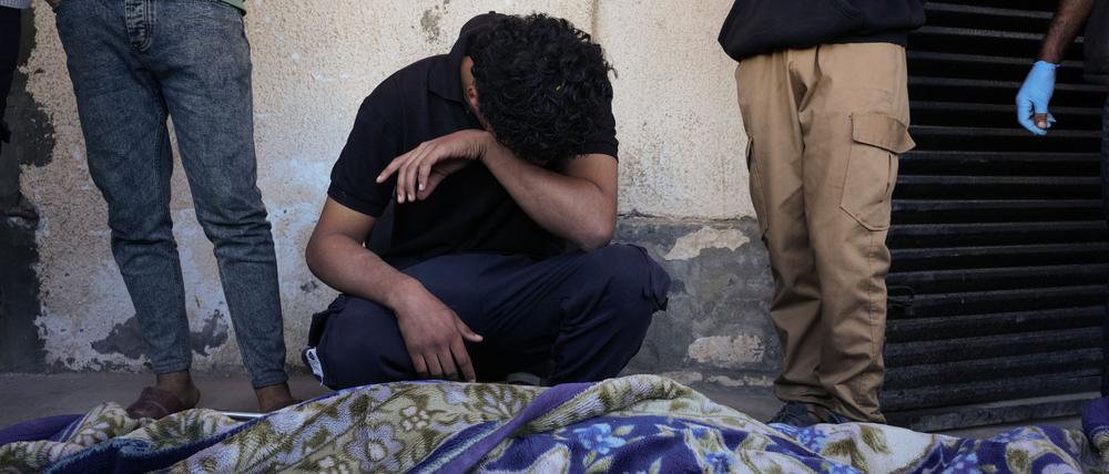 dpatopbilder - 23.11.2025, Palästinensische Gebiete, Deir al-Balah: Ahmed Al-Bohisi trauert um seinen Cousin Mohammad Abu Shawish, 18, der bei einem israelischen Militärschlag getötet wurde, während seiner Beerdigung im Al-Aqsa-Krankenhaus in Deir al-Balah im Gazastreifen. Foto: Abdel Kareem Hana/AP/dpa +++ dpa-Bildfunk +++