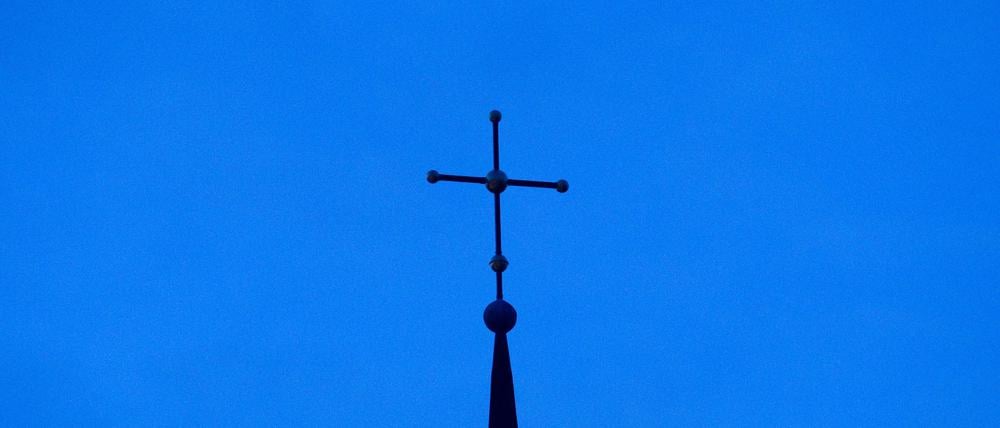 ARCHIV - 28.11.2010, NA, Osnabrück: Das Kreuz einer evangelisch-lutherischen Kirche ist in der Abenddämmerung zu sehen. (zu dpa: «Entwurf zur Reform evangelischer Kirchenbezirke steht») Foto: Friso Gentsch/dpa +++ dpa-Bildfunk +++
