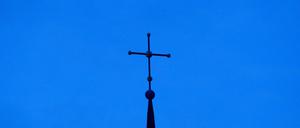 ARCHIV - 28.11.2010, NA, Osnabrück: Das Kreuz einer evangelisch-lutherischen Kirche ist in der Abenddämmerung zu sehen. (zu dpa: «Entwurf zur Reform evangelischer Kirchenbezirke steht») Foto: Friso Gentsch/dpa +++ dpa-Bildfunk +++