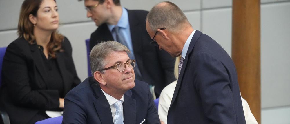 Wolfram Weimer (CDU,l), Staatsminister für Kultur und Medien, spricht mit Bundeskanzler Friedrich Merz (CDU) in der Generaldebatte in der Haushaltswoche im Bundestag. 