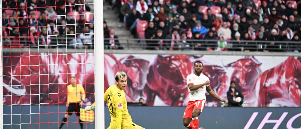 Bremens Torwart Mio Backhaus (l, Werder Bremen) und Ridle Baku (RB Leipzig) schauen dem Ball hinterher. Backhaus verhinderte mit seinen Paraden einen frühen Rückstand der Gäste in Leipzig.