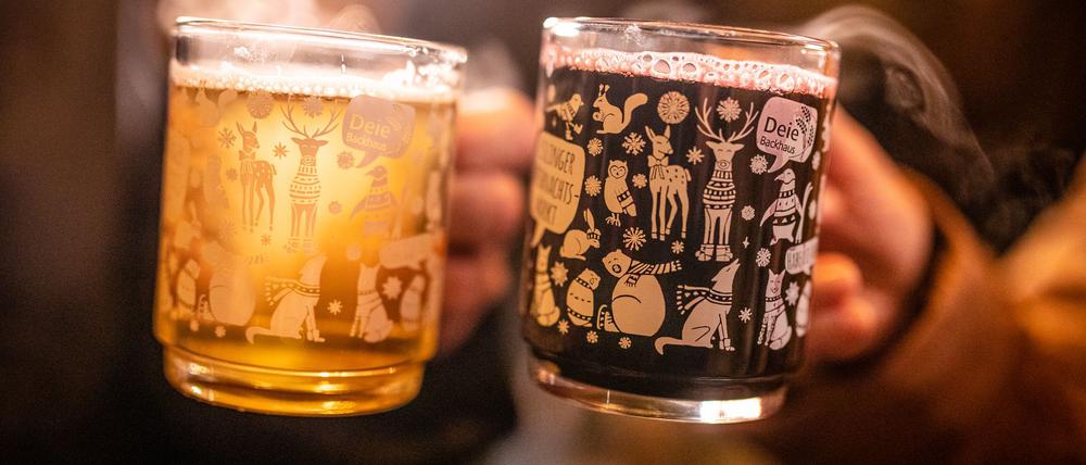 Ein Pärchen stößt auf dem Esslinger Weihnachtsmarkt mit weißem und rotem Glühwein an.