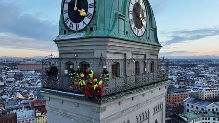 Kräfte der Berufsfeuerwehr München sind am Turm der Kirche St. Peter im Einsatz.