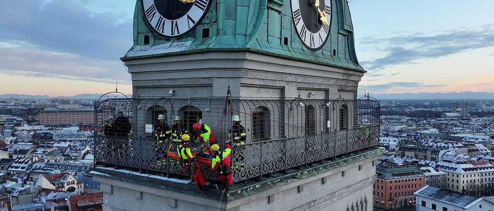 Kräfte der Berufsfeuerwehr München sind am Turm der Kirche St. Peter im Einsatz.