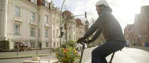 Mit dem Lastenfahrrad zum Friedhof. Eric Wrede transportiert Blumen geschmückte Urnen auch per Rad und die Hinterbliebenen radeln hinterher.