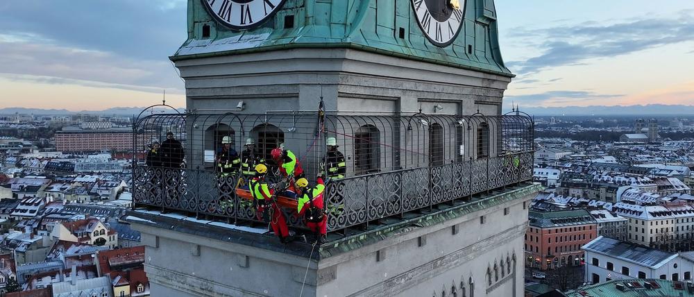 Kräfte der Berufsfeuerwehr München sind am Turm der Kirche St. Peter im Einsatz.