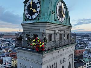 Kräfte der Berufsfeuerwehr München sind am Turm der Kirche St. Peter im Einsatz. 