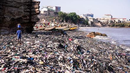 Ein Sandstrand, dessen Sand gar nicht mehr zu sehen ist: Massen an Klamotten vermüllen diesen Küstenabschnitt von Accra. 
