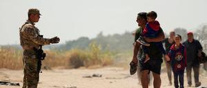 Ein Wachmann gibt Migranten, die den Rio Grande in Mexiko in die USA überquert haben, Anweisungen.