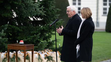 Bundespräsident Frank-Walter Steinmeier (l) und seine Frau Elke Büdenbender schalten die Beleuchtung des Weihnachtsbaums vor dem Schloss Bellevue ein.