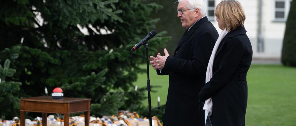 Bundespräsident Frank-Walter Steinmeier (l) und seine Frau Elke Büdenbender schalten die Beleuchtung des Weihnachtsbaums vor dem Schloss Bellevue ein. 