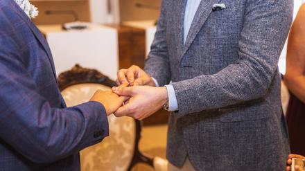 Ein homosexueller Mann steckt bei der Hochzeit seinem Partner den Ring an.