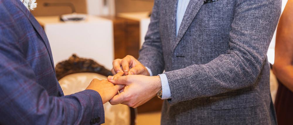 Ein homosexueller Mann steckt bei der Hochzeit seinem Partner den Ring an.