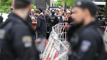 Polizisten stehen vor der Veranstaltungshalle des Palästina-Kongress 2024 vor Teilnehmern, die darauf warten, hereingelassen zu werden. Die propalästinensische Veranstaltung war von der Polizei vorzeitig abgebrochen und verboten worden. Dagegen klagt der Veranstalter vor dem Verwaltungsgericht Berlin.