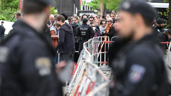 Polizisten stehen vor der Veranstaltungshalle des Palästina-Kongress 2024 vor Teilnehmern, die darauf warten, hereingelassen zu werden. Die propalästinensische Veranstaltung war von der Polizei vorzeitig abgebrochen und verboten worden. Dagegen klagt der Veranstalter vor dem Verwaltungsgericht Berlin.