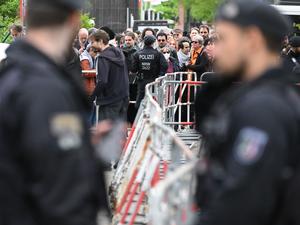Polizisten stehen vor der Veranstaltungshalle des Palästina-Kongress 2024 vor Teilnehmern, die darauf warten, hereingelassen zu werden. Die propalästinensische Veranstaltung war von der Polizei vorzeitig abgebrochen und verboten worden. Dagegen klagt der Veranstalter vor dem Verwaltungsgericht Berlin.