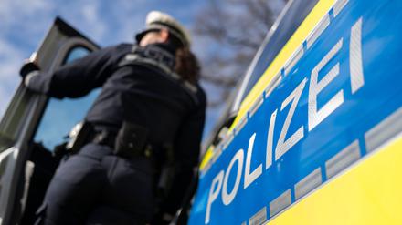 Eine Polizistin der Polizei Baden-Württemberg steht an einem Einsatzfahrzeug. (gestellte Szene)