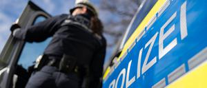 Eine Polizistin der Polizei Baden-Württemberg steht an einem Einsatzfahrzeug. (gestellte Szene)